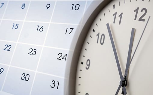 Closeup of a clock and calendar.